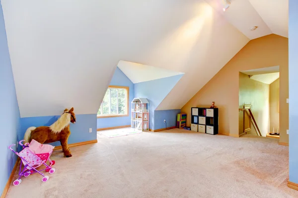 Blue attic living room with toys and play area.
