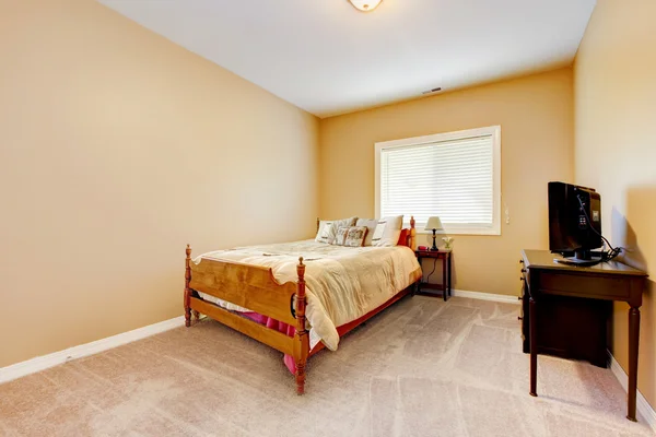 Large bedroom with yellow walls and beige carpet.