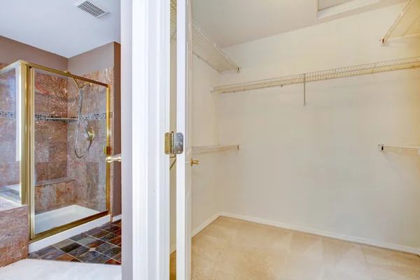 Large walk-in closet and granite shower in the bathroom.