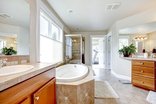 Large bathroom with tub , double sinks and wood cabients.
