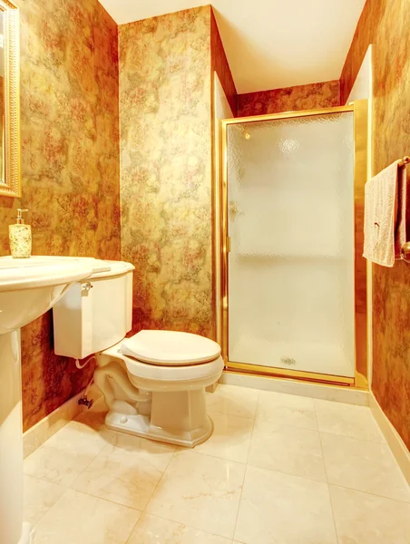 Golden antique bathroom with shower and marble tiles.