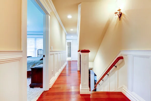 Large bright hallway with cherry hardwood and staircase.