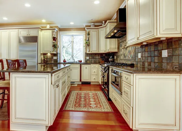 Large luxury white kitchen with cherry hardwood.