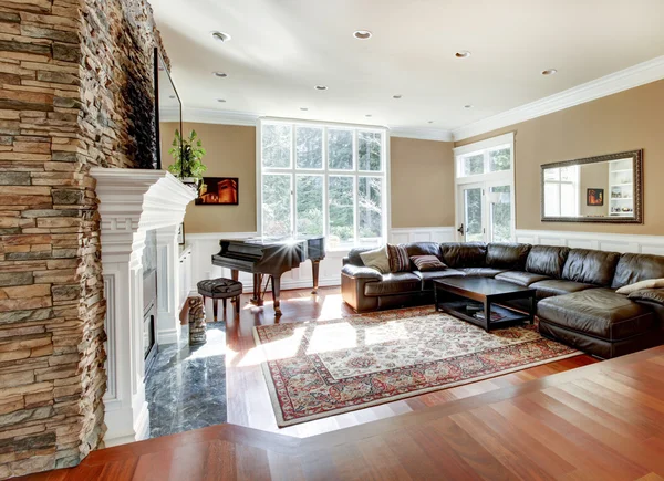 Bright luxury living room with stone fireplace and cherry hardwood.