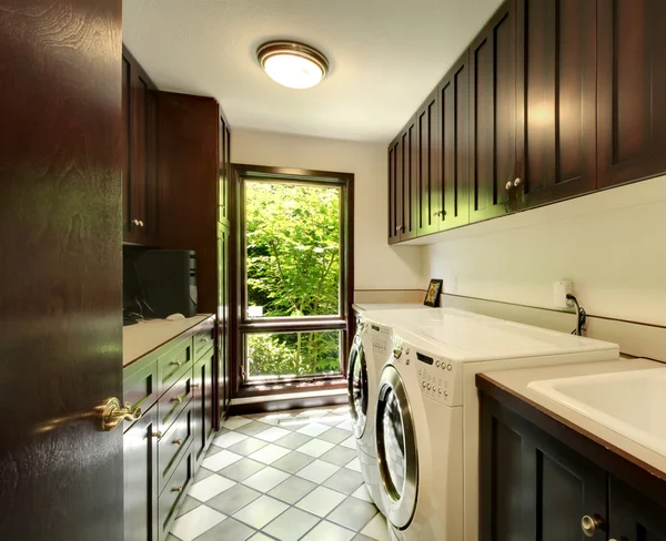 Laundry room with wood cabinets and white washer and dryer.