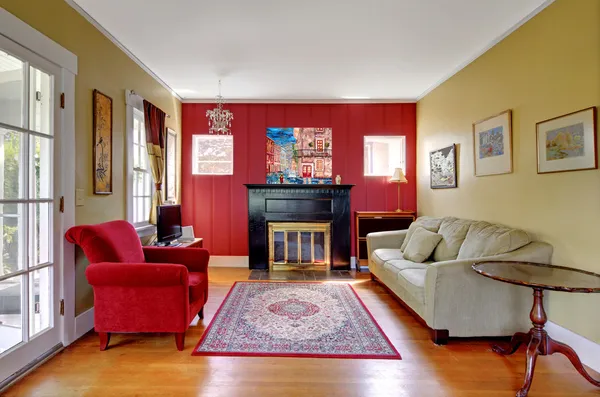 Living room with red and yellow walls and fireplace.