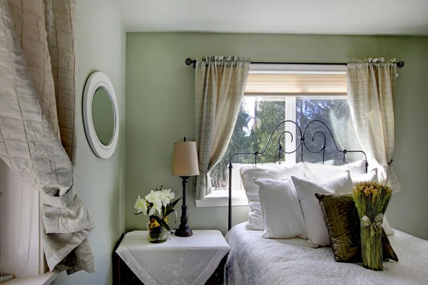 Olive tones bedroom with antique iron frame bed