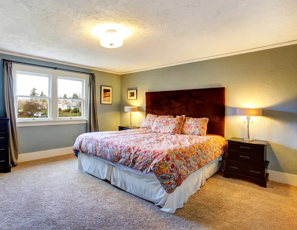 Light blue furnished bedroom with carpeted floor