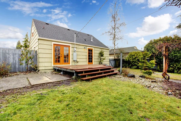 Cozy olive and orange house with backyard deck.