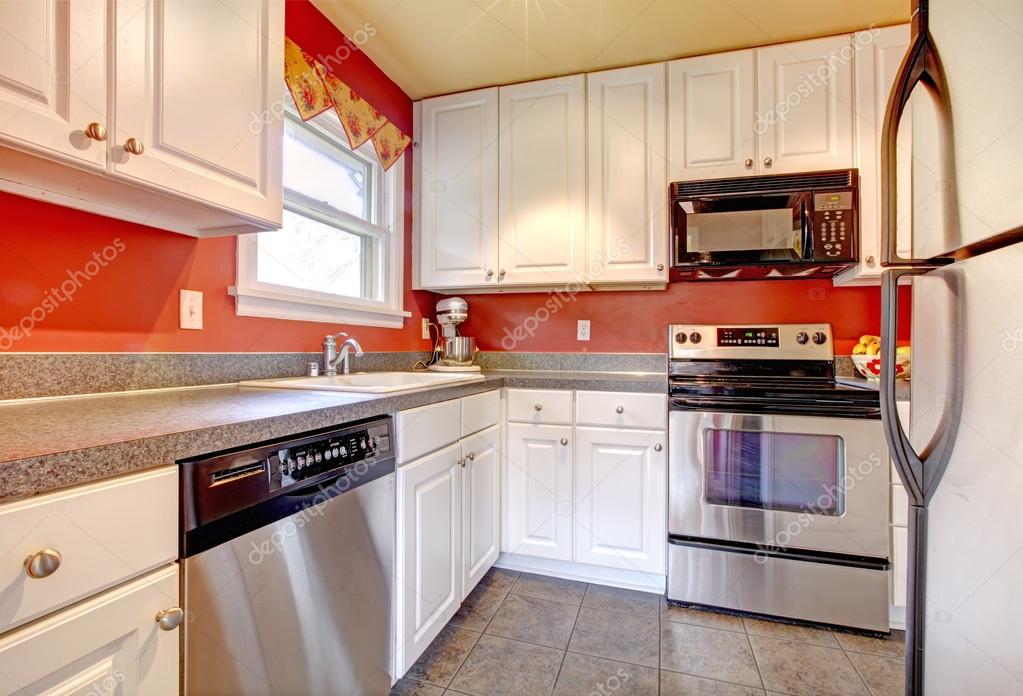 Gezellige keuken kamer met rode muur en wit kasten — stockfoto ...