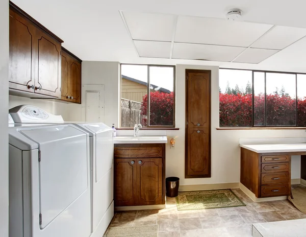 Bright laundry room with dark brown cabinets