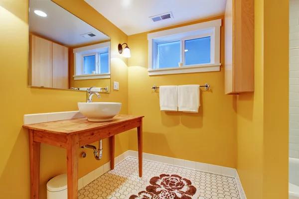 Orange modern bathroom with round sink.