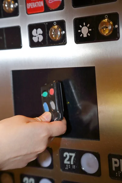 Woman tapping key fob inside elevator