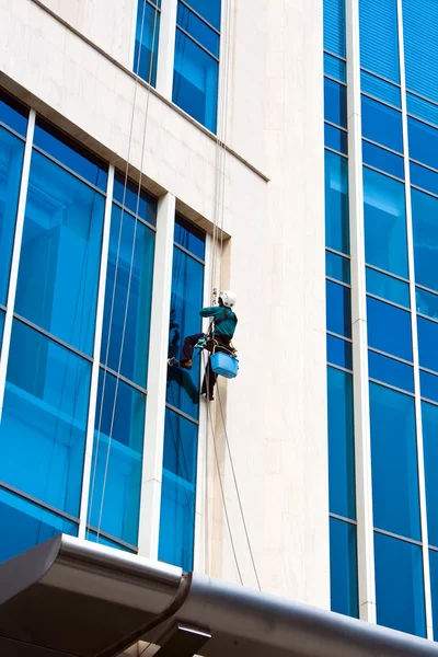 Worker clean mirror on building