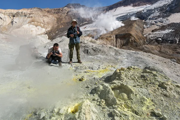 Tourists in the crater of active volcano