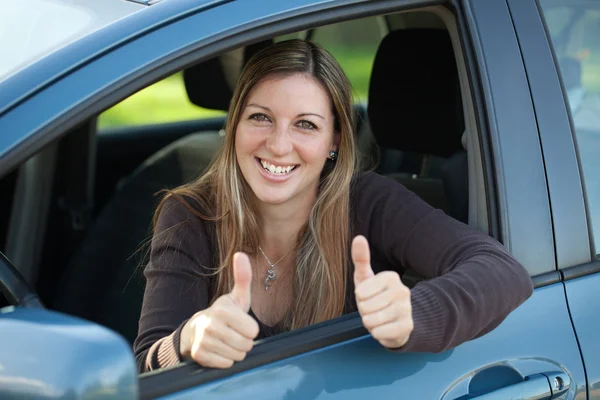 Happy female driver showing thumbs up