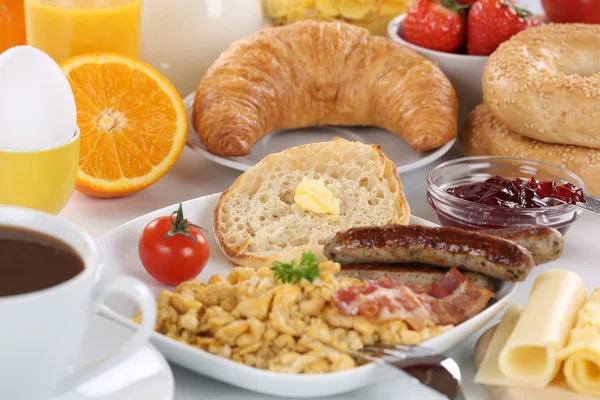 Breakfast with orange juice, marmalade, coffee, bagels, fruits a