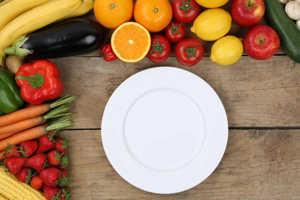 Empty plate framed with vegetables and fruits