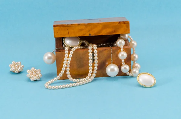 Pearl jewelry retro wooden box on blue background