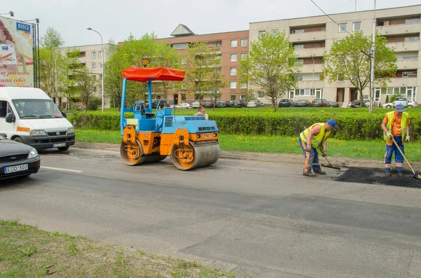 Road roller and asphalt paving machine on street