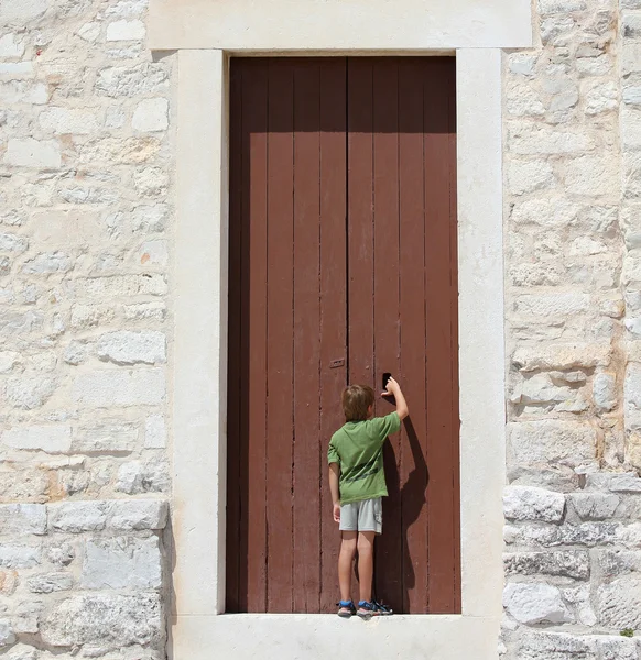 Young boy in front of a big door
