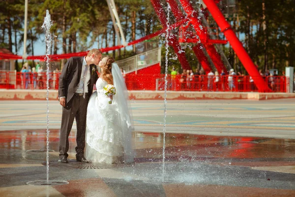 Bride and a groom dance near the fountain