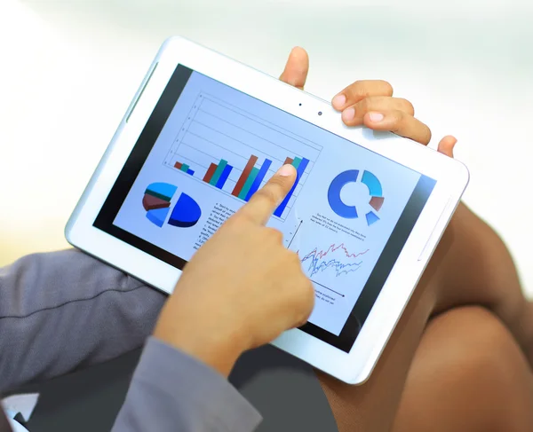 Close-up of businesswoman using tablet computer to work with financial data