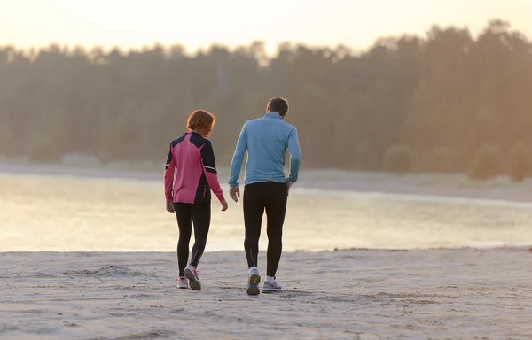 Young man and woman walking along the waterfront