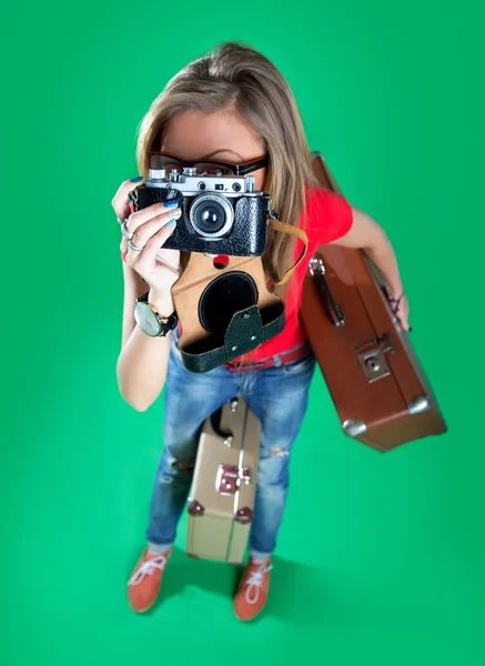 Woman traveler with a camera, green background