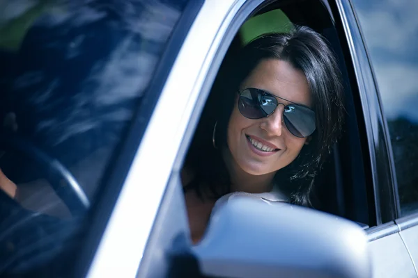 Beautiful young woman driving a car