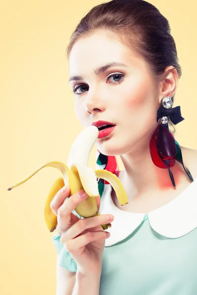 Retro styled woman eating banana