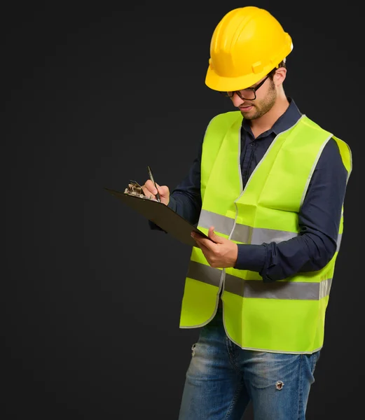 A Young Engineer Holding A Clipboard And Writing