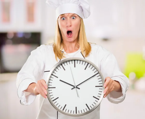 Shocked Female Chef Holding Clock