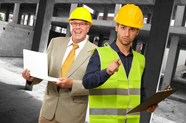 Portrait Of Two Architect Engineers Holding Laptop And Writing P