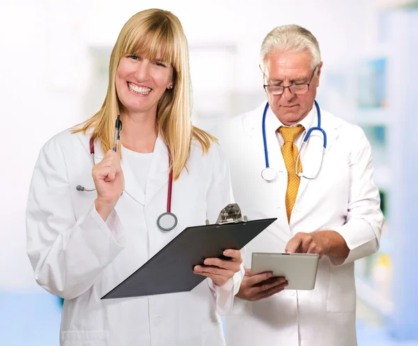 Two Happy Doctors While Holding Clipboard, Tablet