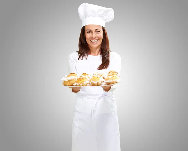 Woman chef holding baked food