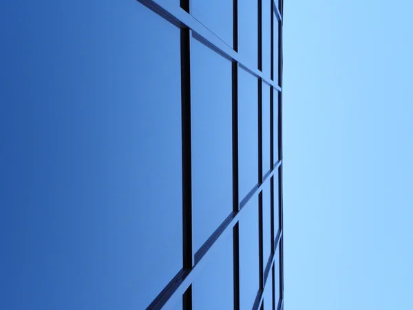 Blue square windows of office bulding in sharp angle, blue sky in top
