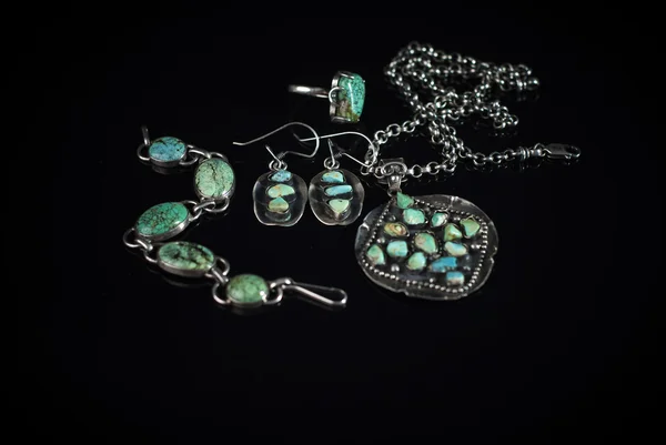 Jewelry from silver and turquoise on black background