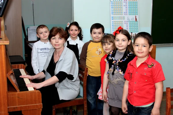 The teacher is engaged with children in music at school