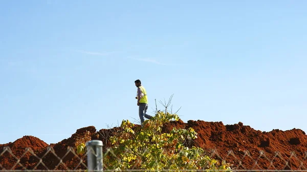 Workers on mound of dirt