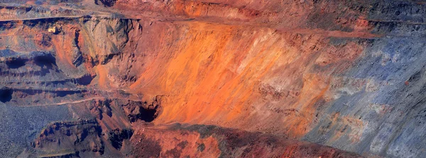 Excavator against iron-ore pit