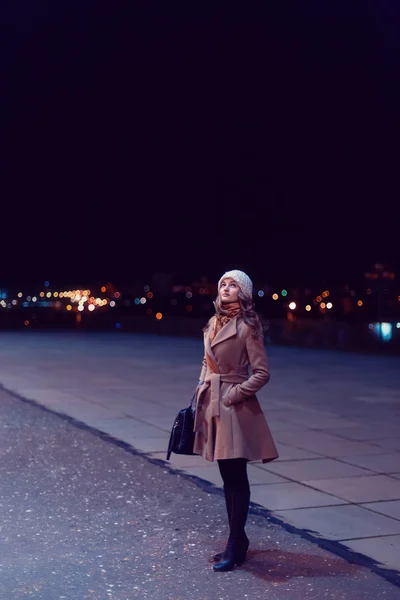 Woman walks on a night city