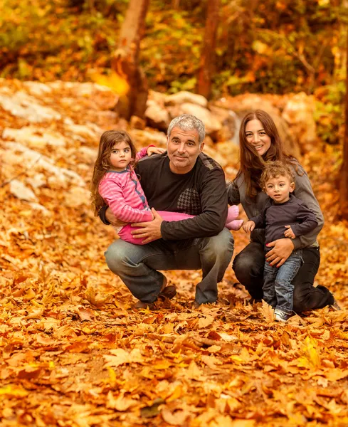 Happy family in autumnal forest