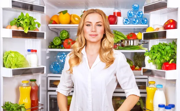 Healthy woman near open fridge