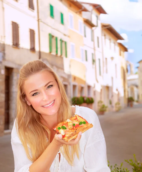 Happy woman eating pizza