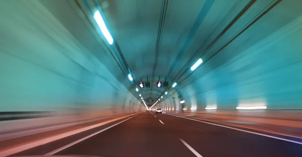 Modern long tunnel on a highway with blue and red light