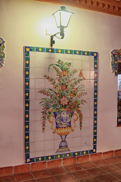 Painted tile mosaic drawing a vase