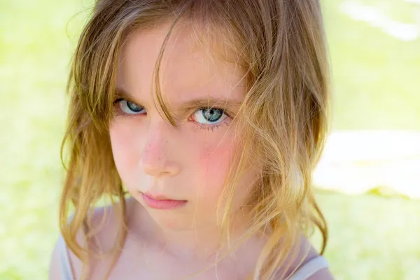 Angry blond children girl portrait looking camera