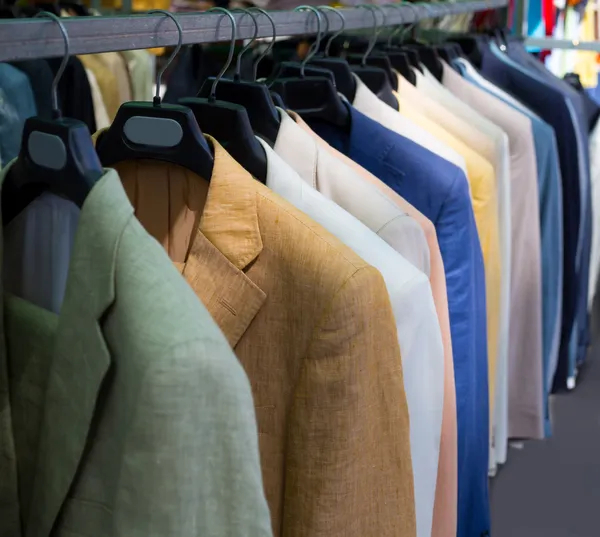 Colorful male suits in row in a hanger