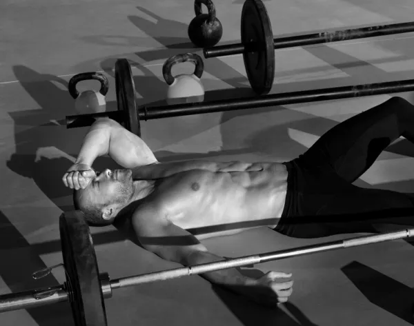 Crossfit man tired relaxed after workout